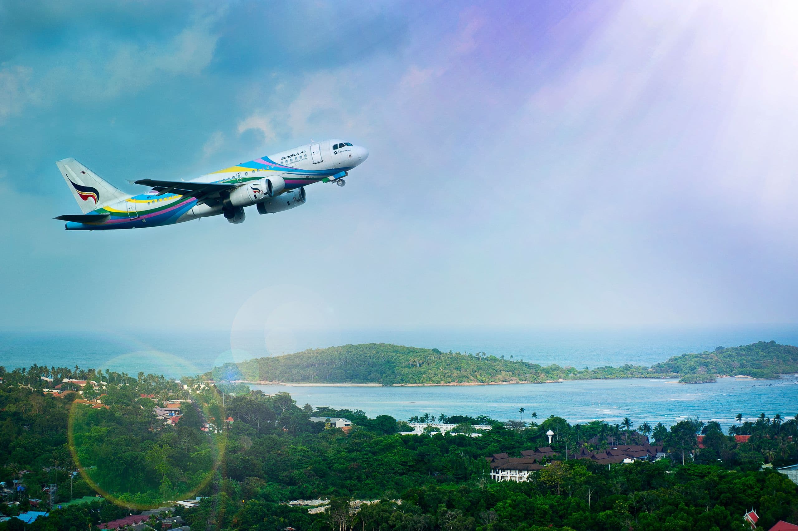 An aircraft climbing away over a tropical coastline